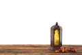 Muslim lamp and dates on wooden table against white background