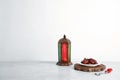 Muslim lantern Fanous, dried dates and prayer beads on table