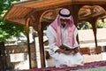 Muslim Man In Dishdasha Is Reading The Quran Royalty Free Stock Photo