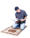 Muslim man is holding holly book Qoran and praying Royalty Free Stock Photo