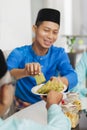 Muslim man holding traditional Malay layer cake