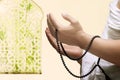 A Muslim man in ihram clothes praying with prayer beads on his hands Royalty Free Stock Photo