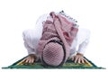 Muslim man with keffiyeh with agal in praying position salat on the prayer rug