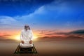 Muslim man with keffiyeh with agal in praying position salat on the prayer rug