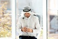 Muslim man with misbaha praying near windows