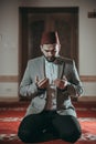 Muslim man praying and reading Quran