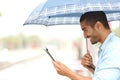 Muslim man reading a tablet under the rain Royalty Free Stock Photo