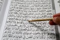 A Muslim man reciting Al-quran. Islam holy book of Muslims, the Quran, is placed on the brown prayer mat. Holy Al Quran with