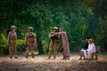 Muslim man stay with family and help by point and guide the way for soldier team during war near the forest Royalty Free Stock Photo