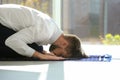 Muslim man in suit praying on rug