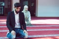 Muslim man and woman praying in mosque