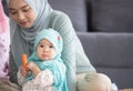 Muslim mom in hijab is her little daughter sitting in the living room, Loving Relationship Royalty Free Stock Photo