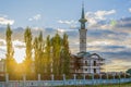 Muslim mosque with minaret lit by sunlight against blue summer cloudy sky. Royalty Free Stock Photo