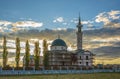 Muslim mosque with minaret lit by sunlight against blue summer cloudy sky. Royalty Free Stock Photo