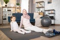 Muslim mother doing sports exercise at home together with funny little daughter Royalty Free Stock Photo