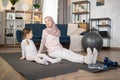 Muslim mother doing sports exercise at home together with funny little daughter Royalty Free Stock Photo