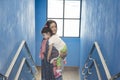 Muslim mother embraced slept little girl and stay in blue building steps