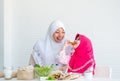 Muslim mother has action for motivating her daughter to eat vegetable, especially fresh tomatoes for good health Royalty Free Stock Photo