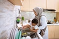 muslim mother wash her son hand in the kitchen sink Royalty Free Stock Photo