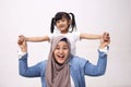 Muslim mother wearing hijab smiling while playing with her baby girl, mom and daughter love each other