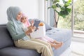 Muslim Mother working with laptop and Cute little baby playing toys in living room at home Royalty Free Stock Photo