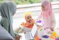 Muslim Mother working with laptop and Cute little baby playing toys in living room at home Royalty Free Stock Photo