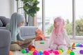 Muslim Mother working with laptop and Cute little baby playing toys in living room at home Royalty Free Stock Photo