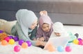 Muslim Mother working with laptop and Cute little baby playing toys in living room at home Royalty Free Stock Photo