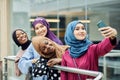 Muslim multiracial student girls in hijabs taking selfie at university hall Royalty Free Stock Photo