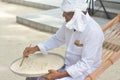 Muslim orthography teacher demonstrate how to write in dhivehi on the sand