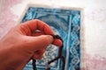 A muslim praying by drawing a rosary, a muslim drawing a close-up rosary