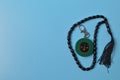 Muslim qibla compass and prayer beads isolated on blue background