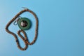 Muslim qibla compass and prayer beads isolated on blue background