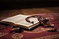 Muslim Quran recitation concept with an opened Quran on a prayer rug with beads. Islamic holy book Quran with Arabic design and