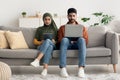 Muslim Spouses Using Laptop And Digital Tablet Computers At Home Royalty Free Stock Photo