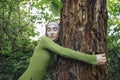 Young female in a hijab and casual clothes in the park. Protecting the environment and caring for plants concept