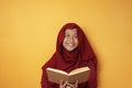 Muslim Teenage Girl Reading Book and Thinking, Happy Smiling Expression Royalty Free Stock Photo