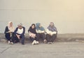 Muslim teens talking together at the sidewalk