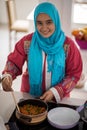 Muslim traditional young girl making food in kitchen