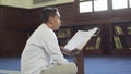 a Muslim was reading the holy verses of the Qur\'an in a mosque on a day with medium close up shot