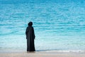 Muslim woman in abaya by the seaside