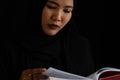 Muslim woman in black Muslim veil hijab reading the Qur'an Royalty Free Stock Photo