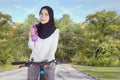 Muslim woman with bottle riding a bike Royalty Free Stock Photo