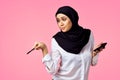 muslim woman with calculator and finance money pink background