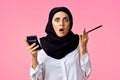 muslim woman with calculator and finance money pink background