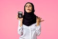 muslim woman with calculator and finance money pink background