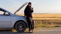 Muslim woman calling help phone near open hood of car Royalty Free Stock Photo