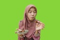 muslim woman eating dates during iftar with green background