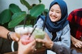 Muslim woman with friend toast her drink Royalty Free Stock Photo