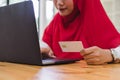 Muslim woman hands holding credit card and using laptop for online shopping. Royalty Free Stock Photo